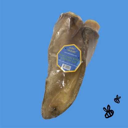 one crunchy full-sized honey coated buffalo ear. blue background, two black honey bees, bottom right