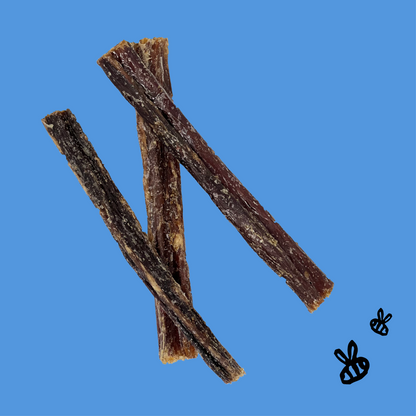threee buffalo gullet sticks on blue background. 2 black bees drawn in bottom right corner